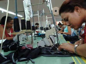 mujer cosiendo en una zona franca