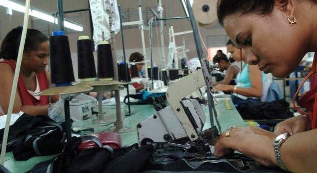 mujer cosiendo en una zona franca