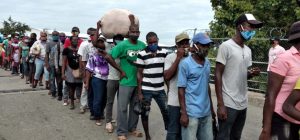 SANTIAGO.-El mercado binacional  de Dajabón reinició sin contratiempos este viernes bajo la aplicación de un estricto protocolo por las autoridades del Ministerio de Salud Pública,  miembros del  Cuerpo Especializado en Seguridad Fronteriza Terrestre (Cesfront) y otras autoridades, para evitar la propagación del covid-19.  Desde tempranas horas de la mañana de hoy, las autoridades aplican el protocolo acordado la semana pasada,  de que a territorio dominicano solo entrarían haitianos de 50 en 50,  para participar en  el intercambio comercial.  Tanto a dominicanos como haitianos se le exige  el uso obligatorio de mascarillas, lavado de manos y el distanciamiento social.  El intercambio comercial llevaba varios meses suspendido por la pandemia.   El periodista de Dajabón, Carlos Bueno, dijo que hasta media mañana de este viernes, todo transcurría con normalidad.    Ayer,  el director  del Gabinete del Ministerio de Salud Pública,  Robinson Díaz dijo que se acordó que el comercio funcionará lunes y viernes de 8:00 de la mañana a 5:00pm donde se realizarán pruebas para detectar covid-19 y que 35 supervisores de esa institución velarán por el cumplimiento de las reglas establecidas en la pandemia.  Mientras,  que el presidente de la Federación de Comerciantes de Dajabón, Freddy Morillo, explicó que el plan piloto y el protocolo acordado están siendo aplicados tanto para haitianos como dominicanos.  “Este será un comercio limitado tanto para haitianos como dominicanos, en ese sentido los comerciantes haitianos se han organizado y se ha dispuesto que conjuntamente con las autoridades haitianas y dominicanas, coordinadas ambas, pasen los haitianos de 50 en 50”, apuntó Morillo.  Señaló que una comisión encabezada por el alcalde de Dajabón, Santiago Riverón y además integrada por empleados de las direcciones de Migración, Aduanas, los comerciantes, el Cesfront y el Ministerio de Salud Pública, estarán monitoreando el desarrollo comercial.  “Para cualquier detalle o cualquier situación mantenerla controlada.  Lo que podemos decir que aquí en Dajabón el intercambio comercial está transcurriendo con mucho orden bajo la supervisión de las autoridades “, agregó el comerciante.  Con la reapertura del mercado binacional en Dajabon,  los comerciantes de allí dicen esperar que se dinamice el comercio.   Trascendió que con este  plan piloto y protocolo diseñado por el Ministerio de Salud Pública se podría replicar en los demás puntos fronterizos.  El pasado sábado durante un encuentro en territorio haitiano, los alcaldes de Dajabón, Santiago Riverón,  de Juana Méndez, Haití, Lumas Demetrius y el director regional del Ministerio de Industria y Comercio, Lorenzo Taveras,  comerciantes haitianos y dominicanos acordaron reabrir hoy el intercambio comercial aplicando protocolos de un plan piloto establecido para el abordaje de la covid-19.