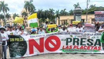 Santo Domingo, DN. - En una manifestación sin precedentes, cientos de serranos se congregaron frente al Palacio Nacional para manifestar su rechazo al proyecto de construcción de la presa de Las Placetas, exigiendo al presidente Luis Abinader que desista de su realización. Esta iniciativa, de llevarse a cabo, tendría consecuencias desastrosas, ya que secaría los ríos Jagua y Bao, fuentes vitales de agua en la región. Los serranos, organizados en la Coalición Socioambiental en defensa de La Sierra y respaldados por la Red Socioambiental Nacional, la Coordinadora Popular Nacional y otras organizaciones de diferentes puntos del país, denunciaron enérgicamente los daños al medio ambiente que ocurren ante la mirada indiferente de las autoridades, y en muchos casos, con la complicidad del Ministerio de Medio Ambiente. Durante la concentración, los manifestantes leyeron un manifiesto que le se exige al gobierno la cancelación del proyecto de la presa de Las Placetas, así como de otras obras que están generando una calamidad ambiental en el país y que desista del intento de privatizar el agua. El llamado se hizo de forma oportuna, previo al Día Internacional del Medio Ambiente, que se celebra este lunes 5 de junio. La presa de Las Placetas ha generado un gran rechazo desde su anuncio inicial en el 2007. Los opositores al proyecto argumentan que la construcción de la presa provocaría la desaparición de los ríos Jagua y Bao, lo que tendría un impacto devastador en el ecosistema local y en las comunidades que dependen de estas fuentes de agua. “Emplazamos al presidente Luis Abinader, al conjunto del Gobierno y la élite financiera y empresarial a que en el curso de este mes de junio respondan las demandas y propuestas de las comunidades y sectores movilizados por sus derechos hoy desplegados aquí frente al Palacio Nacional”. Dijo Llaniris Espinal activista de la Coalición Socioambiental de La Sierra y la Fundación Ecológica Tropical (FUNDETROP). La manifestación también contó con la presencia de destacadas figuras del activismo medioambiental nacional, quienes expresaron su apoyo a los serranos y resaltaron la urgencia de tomar medidas concretas para evitar la destrucción de los recursos naturales del país. Hasta el momento, el gobierno no ha emitido una respuesta oficial ante las demandas de los manifestantes. Sin embargo, la presión ejercida por los serranos y las organizaciones ambientales ha generado un intenso debate público sobre la necesidad de proteger el medio ambiente y tomar decisiones responsables en relación con el desarrollo de proyectos que afecten los recursos naturales. La lucha de los serranos contra la presa de Las Placetas se empodera aun más llegando hasta el Palacio Nacional, recordando a todos la importancia de preservar los ríos Jagua y Bao, y proteger el entorno natural para las generaciones presentes y futuras.